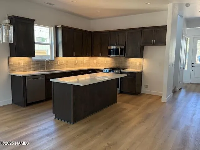 a kitchen with stainless steel appliances granite countertop a stove a sink and a refrigerator