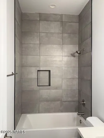 a white toilet sitting next to a bath tub