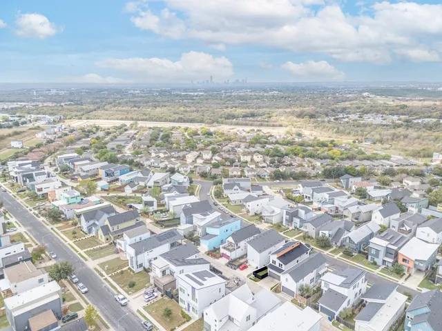 an aerial view of residential houses with city view