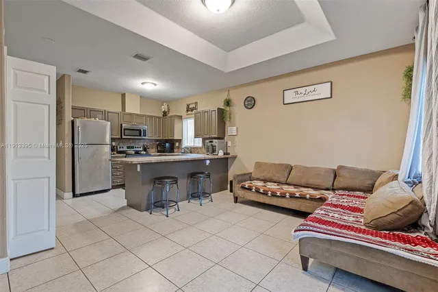 a living room with furniture and kitchen view