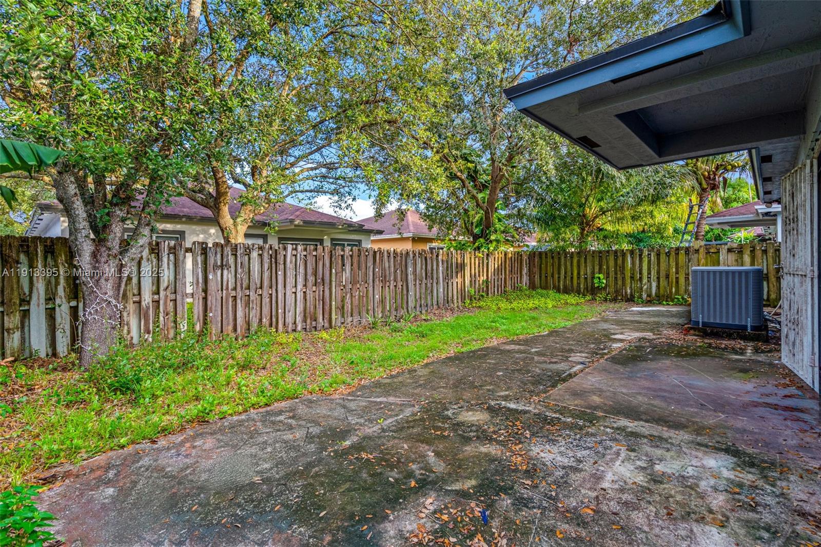 211 Southwest 15th Terrace Homestead, FL 33030 - Photo 24 of 26 a view of a backyard with wooden fence and a large tree