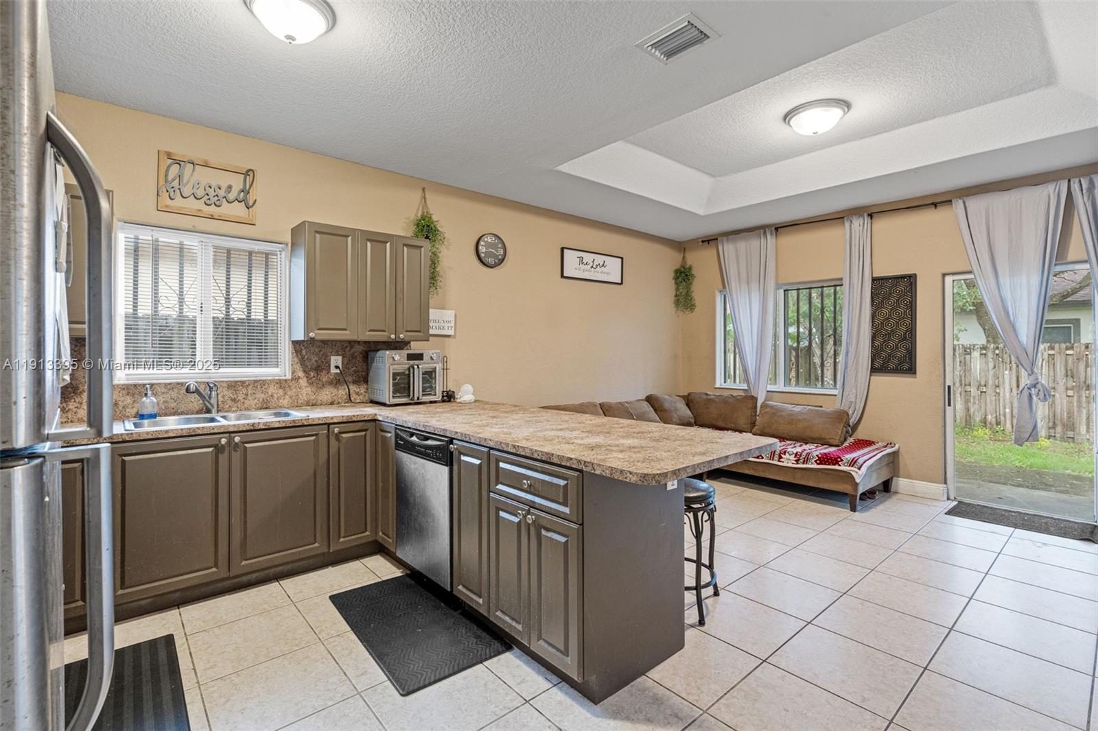 211 Southwest 15th Terrace Homestead, FL 33030 - Photo 8 of 26 a kitchen with stainless steel appliances granite countertop a stove a sink and a microwave