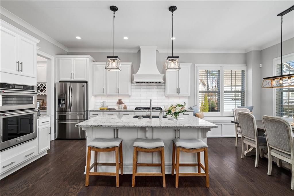 165 Rowan Avenue Alpharetta, GA 30009 - Photo 19 of 84 a kitchen with stainless steel appliances a dining table chairs stove and refrigerator