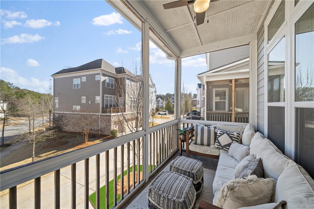 165 Rowan Avenue Alpharetta, GA 30009 - Photo 27 of 84 a view of a balcony with couches wooden floor and a floor to ceiling window