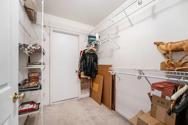 a view of walk in closet with clothes and shoes