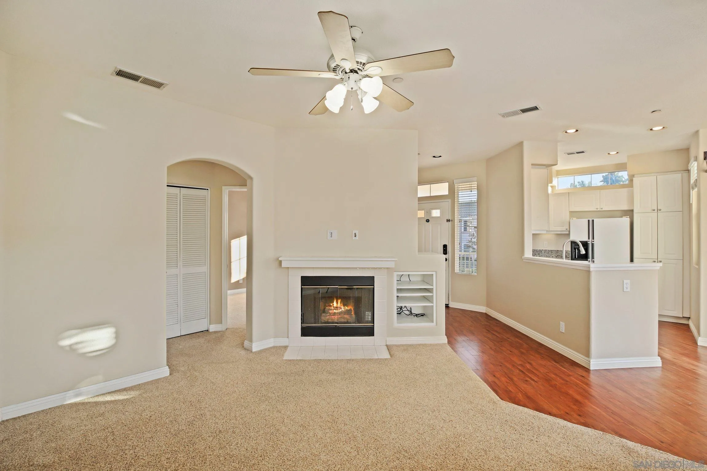 a view of a livingroom with a fireplace a chandelier and wooden floor
