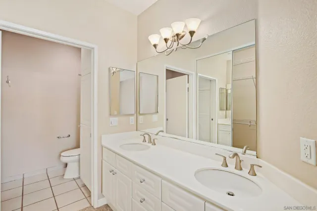 a bathroom with a double vanity sink mirror and toilet