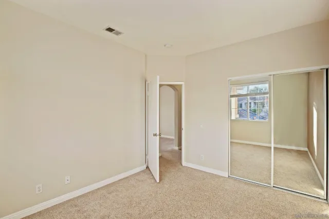 an empty room with closet and a window