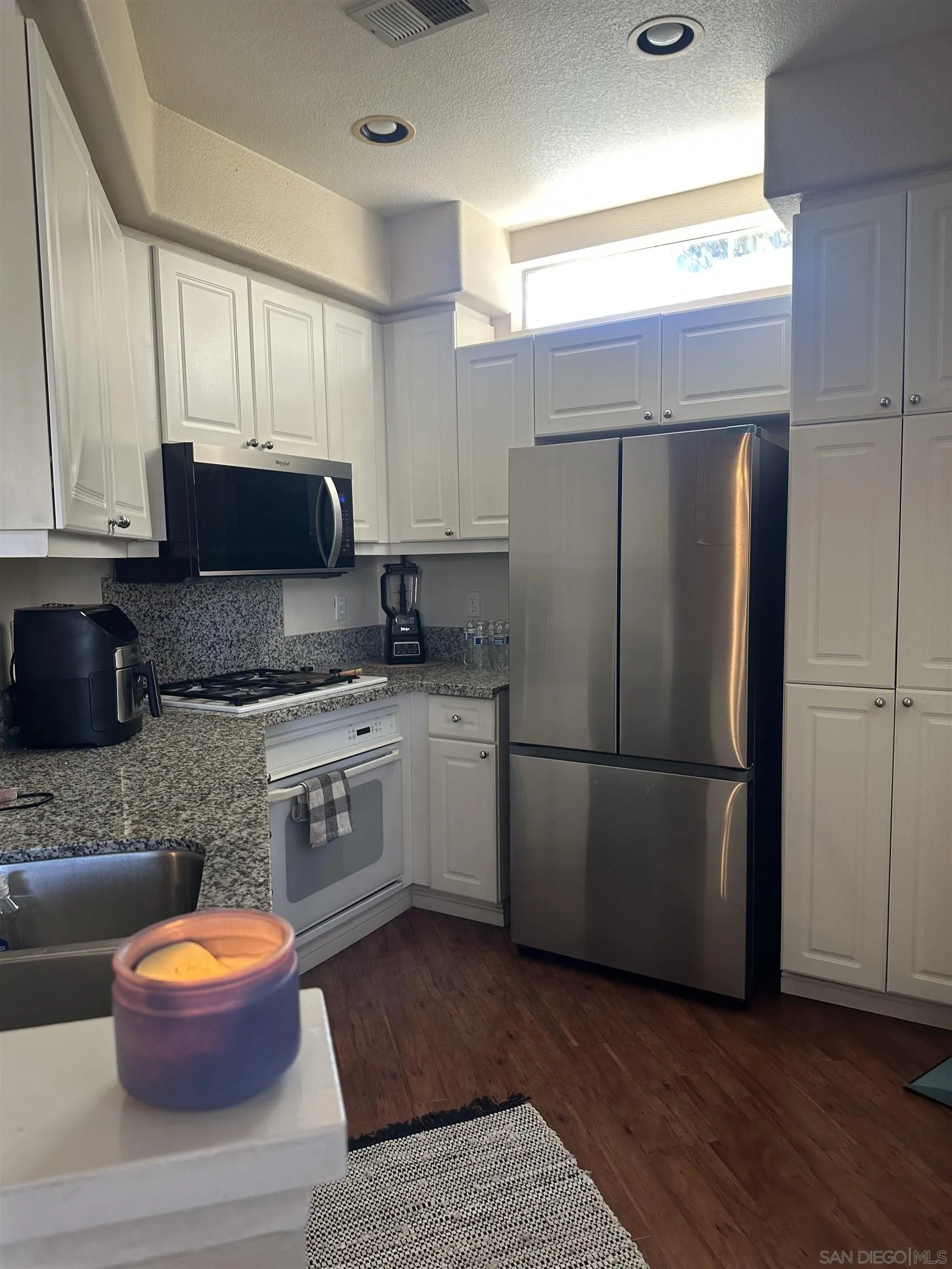 10766 Sabre Hill Drive, Unit 258 San Diego, CA 92128 - Photo 7 of 18 a kitchen with stainless steel appliances granite countertop a refrigerator a stove a sink and a microwave
