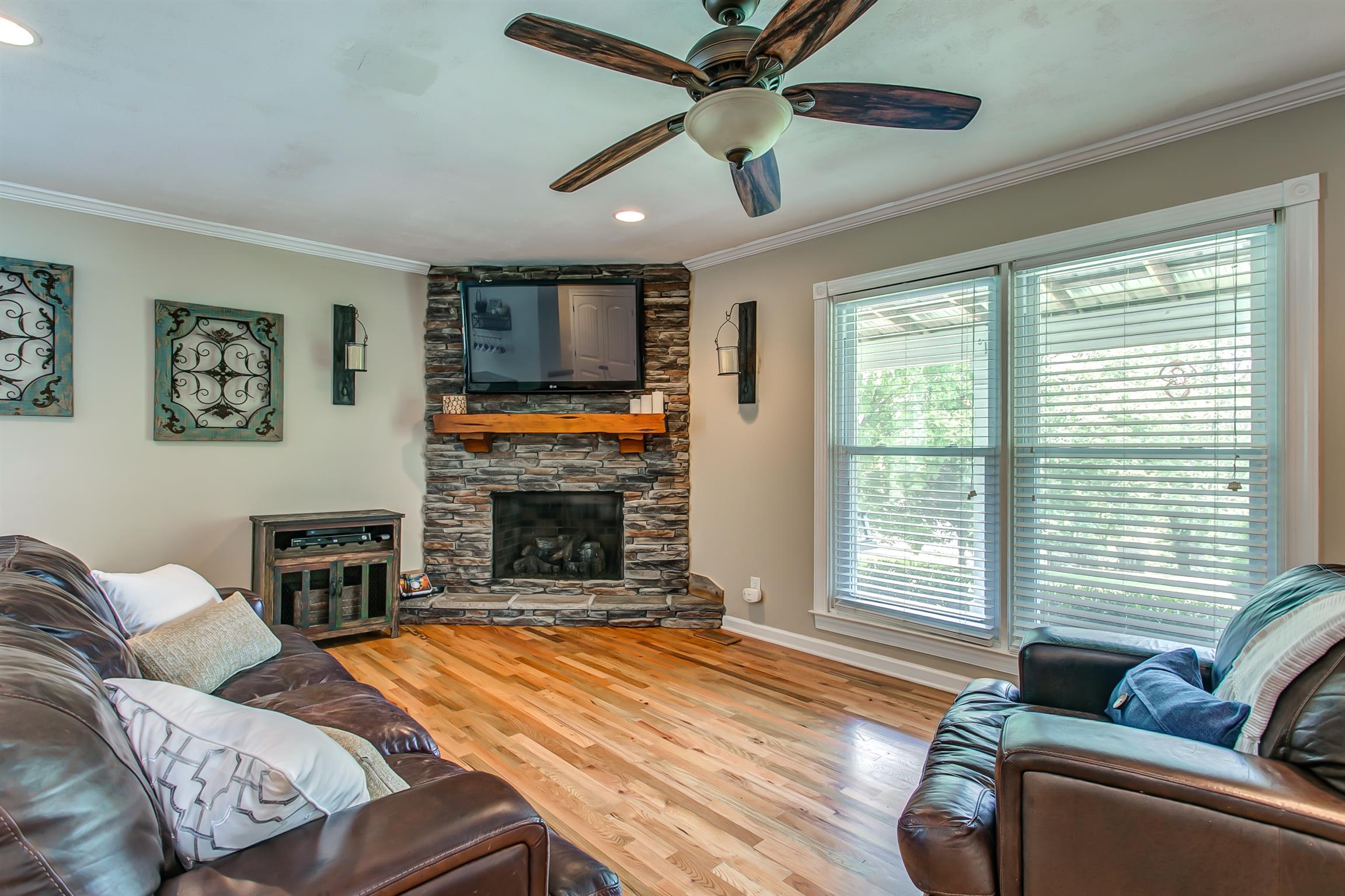 4432 Harpeth School Road Franklin, TN 37064 - Photo 5 of 30 Cozy up for a movie, or watch your favorite sports team play in the home's sun-soaked living room featuring canned lighting, gas stack stone fireplace and ceiling fan.