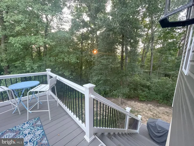 a balcony with wooden floor and outdoor seating
