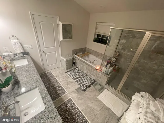 a bathroom with a granite countertop sink a toilet and shower