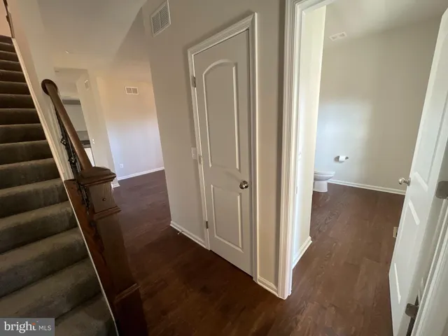 a view of a hallway with wooden floor and stairs