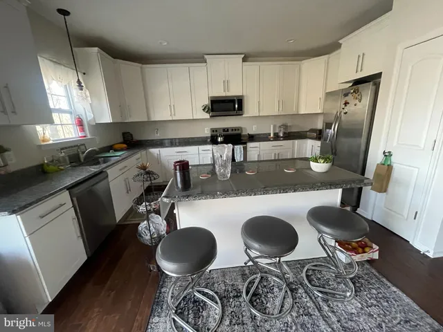 a kitchen with sink a stove a refrigerator and cabinets