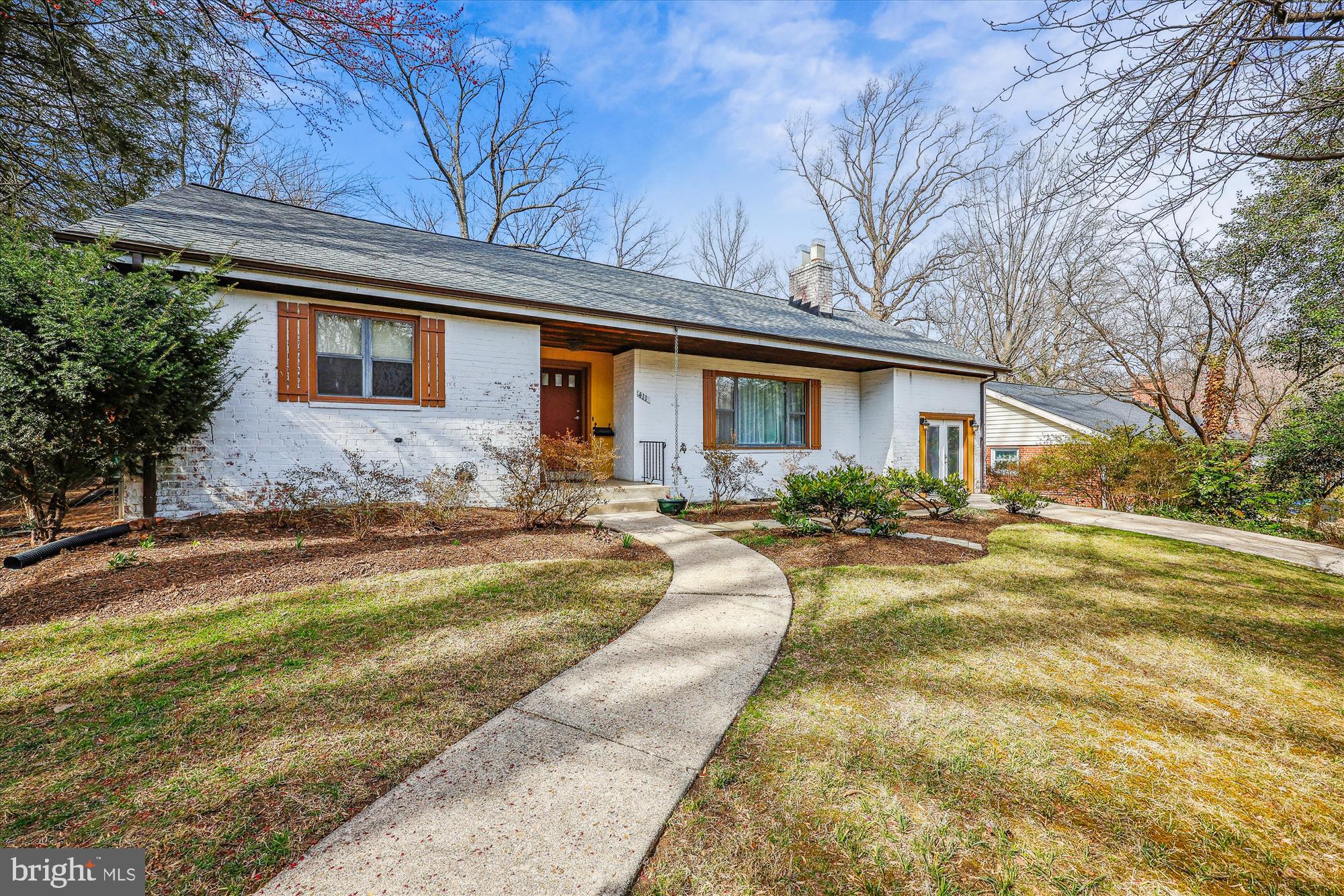 a front view of house with yard and trees around