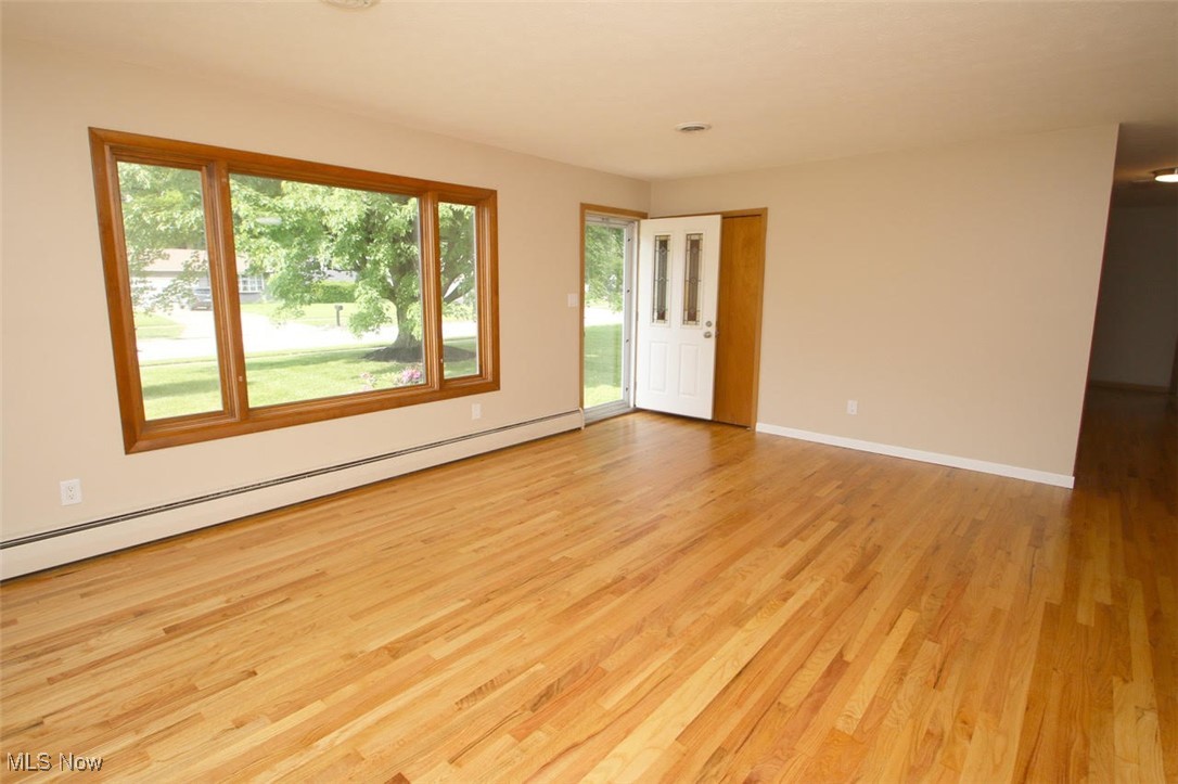 7958 Bellflower Road Mentor, OH 44060 - Photo 2 of 34 Unfurnished room with a baseboard heating unit, wood finished floors, and healthy amount of natural light
