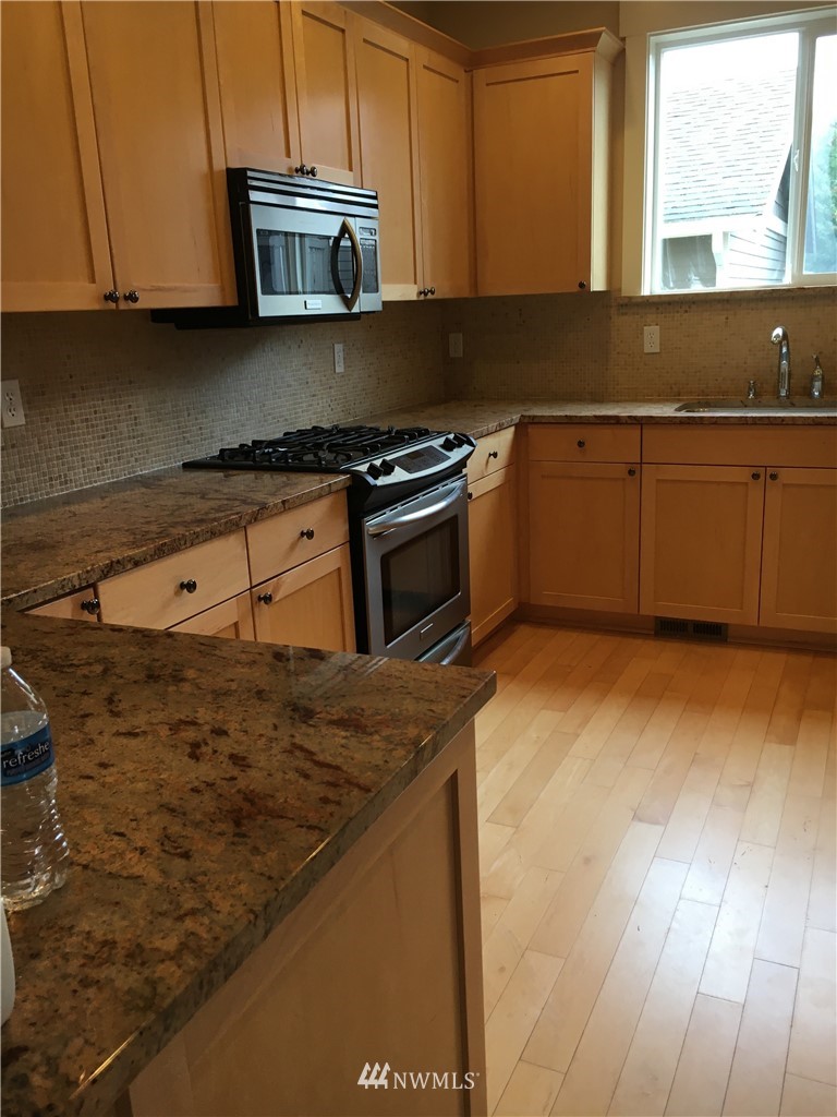 308 Northwest 89th Street Seattle, WA 98117 - Photo 3 of 9 a kitchen with stainless steel appliances granite countertop a sink stove and microwave