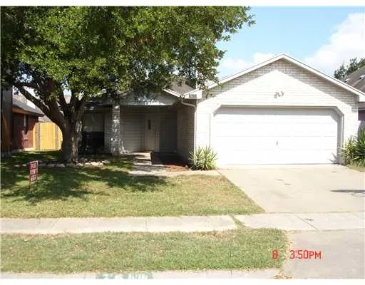 a view of a house with a yard and large tree