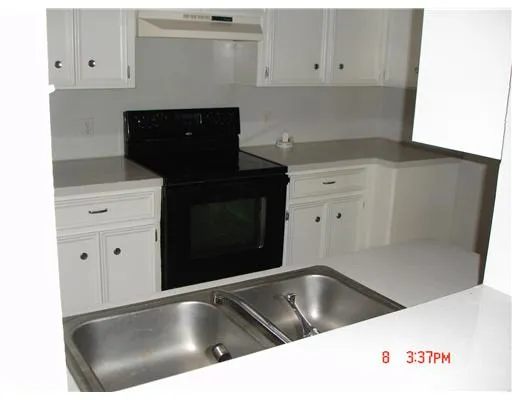 a close view of a stove sink and cabinets