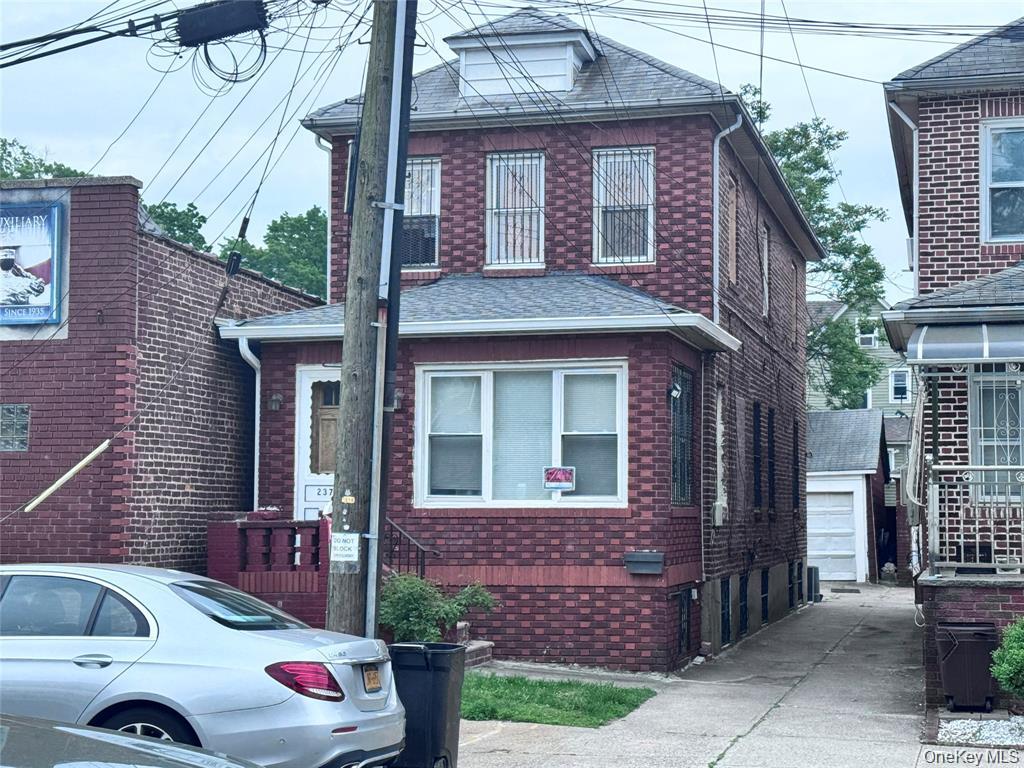 View of front of house with brick siding and roof with shingles