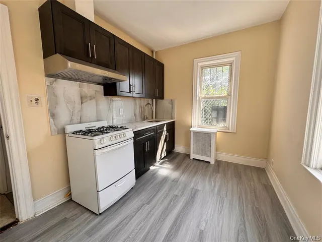 a kitchen with granite countertop wooden floors and white stainless steel appliances