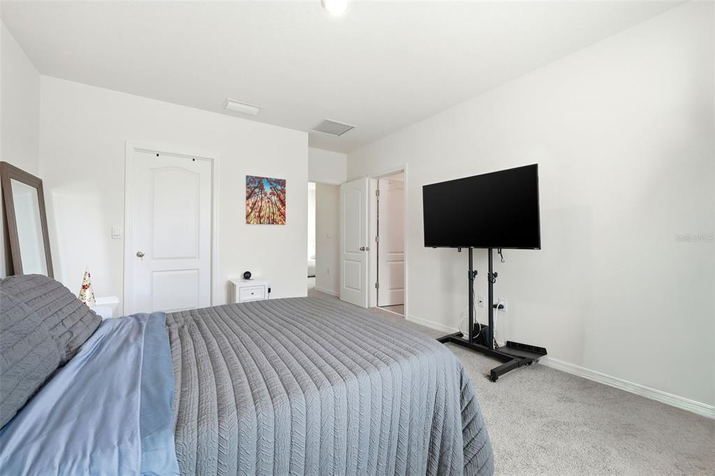 1503 Isleta Loop Kissimmee, FL 34741 - Photo 25 of 50 a bedroom with a bed and a flat screen tv