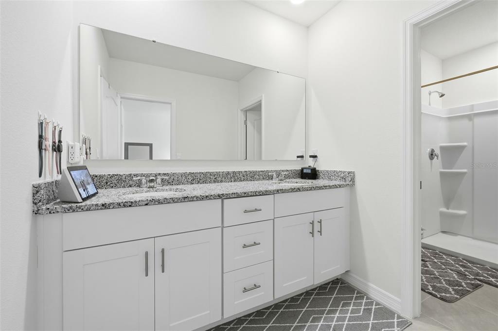 1503 Isleta Loop Kissimmee, FL 34741 - Photo 27 of 50 a bathroom with a granite countertop sink and a mirror