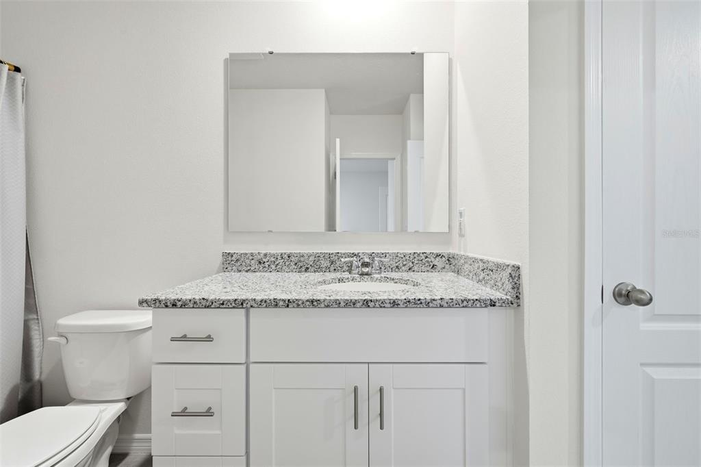 1503 Isleta Loop Kissimmee, FL 34741 - Photo 34 of 50 a bathroom with a granite countertop sink and a toilet
