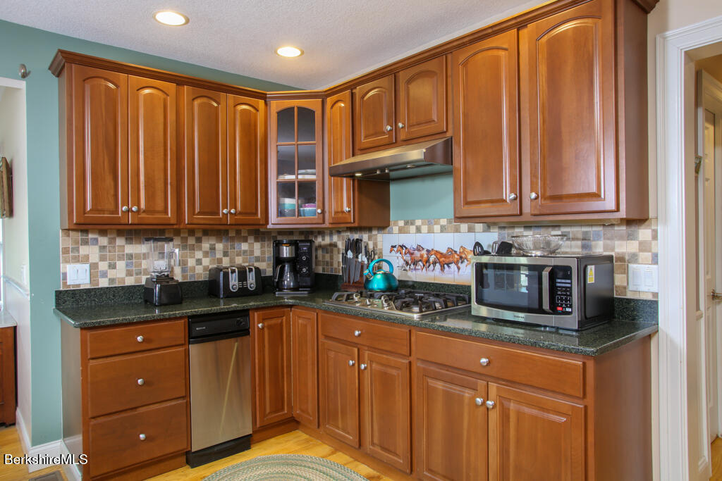 200 Easthampton Road Westhampton, MA 01027 - Photo 7 of 69 a kitchen with stainless steel appliances granite countertop a refrigerator and wooden cabinets