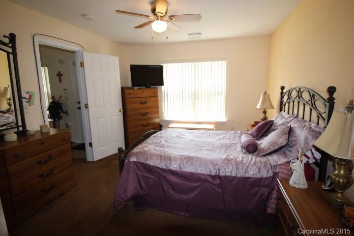 8304 Rudolph Road, Unit 8304 Charlotte, NC 28216 - Photo 8 of 20 a bedroom with a bed and a flat tv screen on the dresser