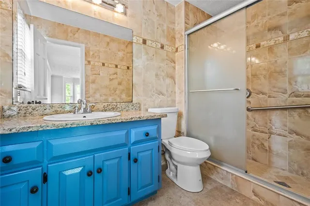a bathroom with a granite countertop toilet sink and a shower