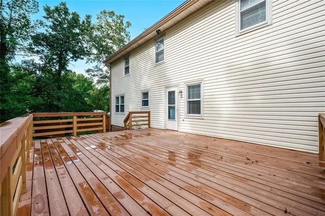 a backyard of a house with wooden floor table and chairs