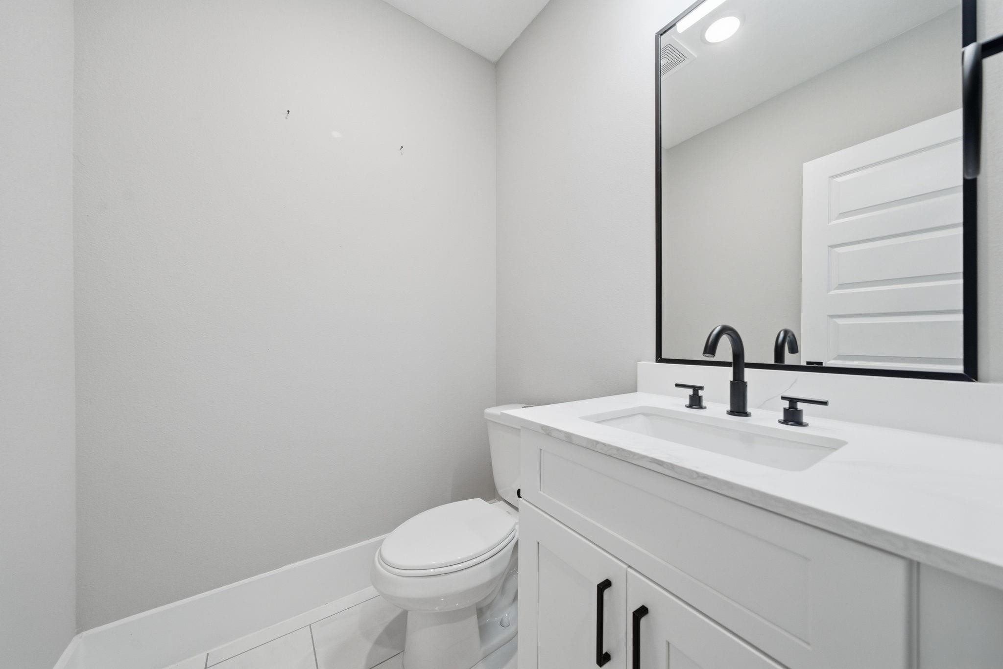 4013 Griggs Road, Unit F Houston, TX 77021 - Photo 10 of 35 Sleek and modern bathroom featuring a stylish vanity with dual faucets, a large framed mirror, and contemporary fixtures.