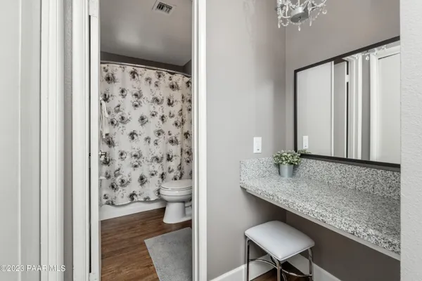 a bathroom with a granite countertop toilet sink and mirror