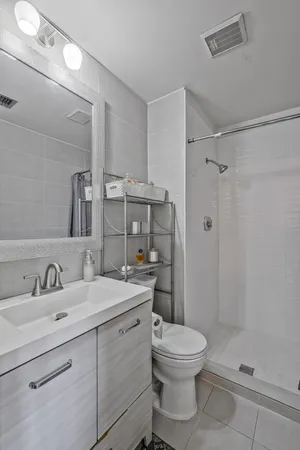 a bathroom with a toilet sink a shower and a mirror