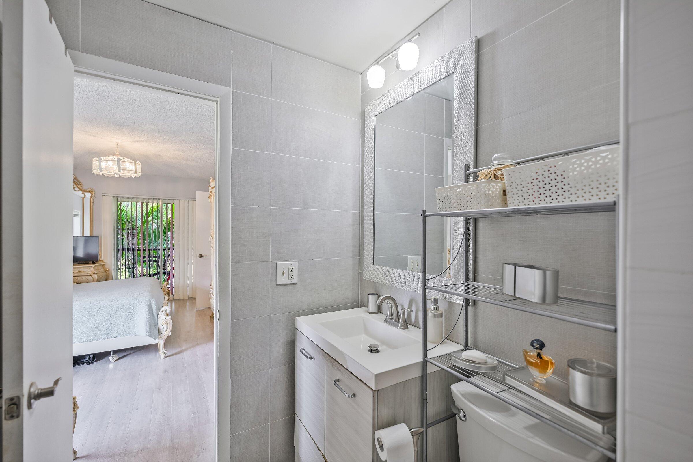 6544 Chasewood Drive, Unit H Jupiter, FL 33458 - Photo 13 of 14 a bathroom with a sink and a mirror