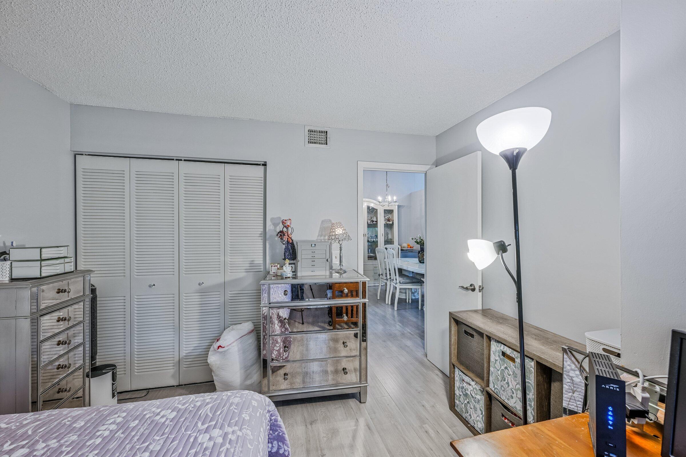6544 Chasewood Drive, Unit H Jupiter, FL 33458 - Photo 14 of 14 a bedroom with furniture and a chandelier