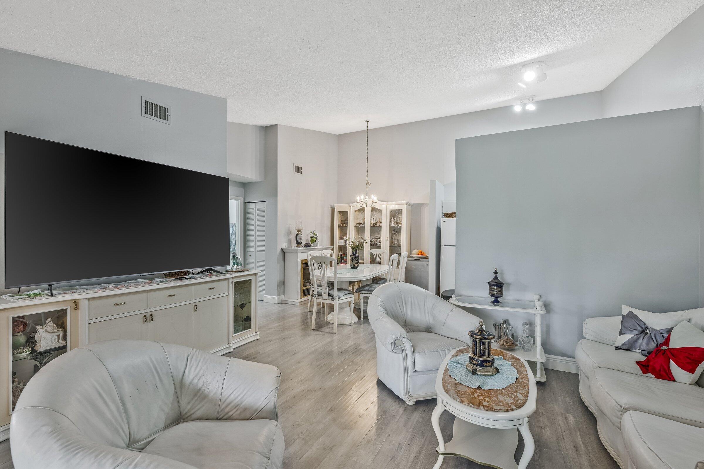 6544 Chasewood Drive, Unit H Jupiter, FL 33458 - Photo 5 of 14 a living room with furniture and a flat screen tv
