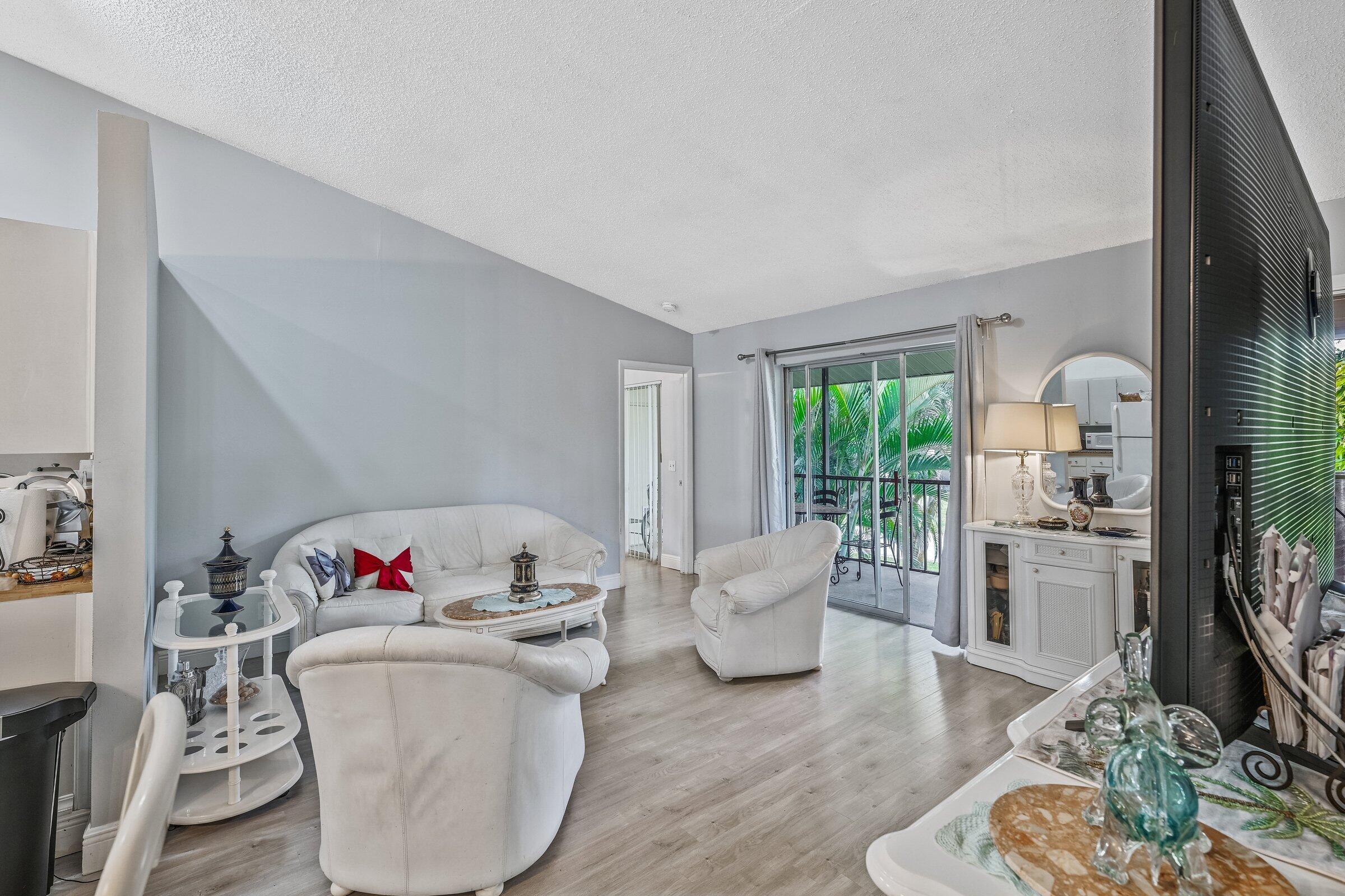 6544 Chasewood Drive, Unit H Jupiter, FL 33458 - Photo 6 of 14 a living room with furniture and a wooden floor