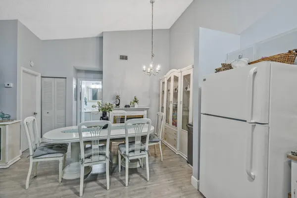 a kitchen with stainless steel appliances a refrigerator and a dining table