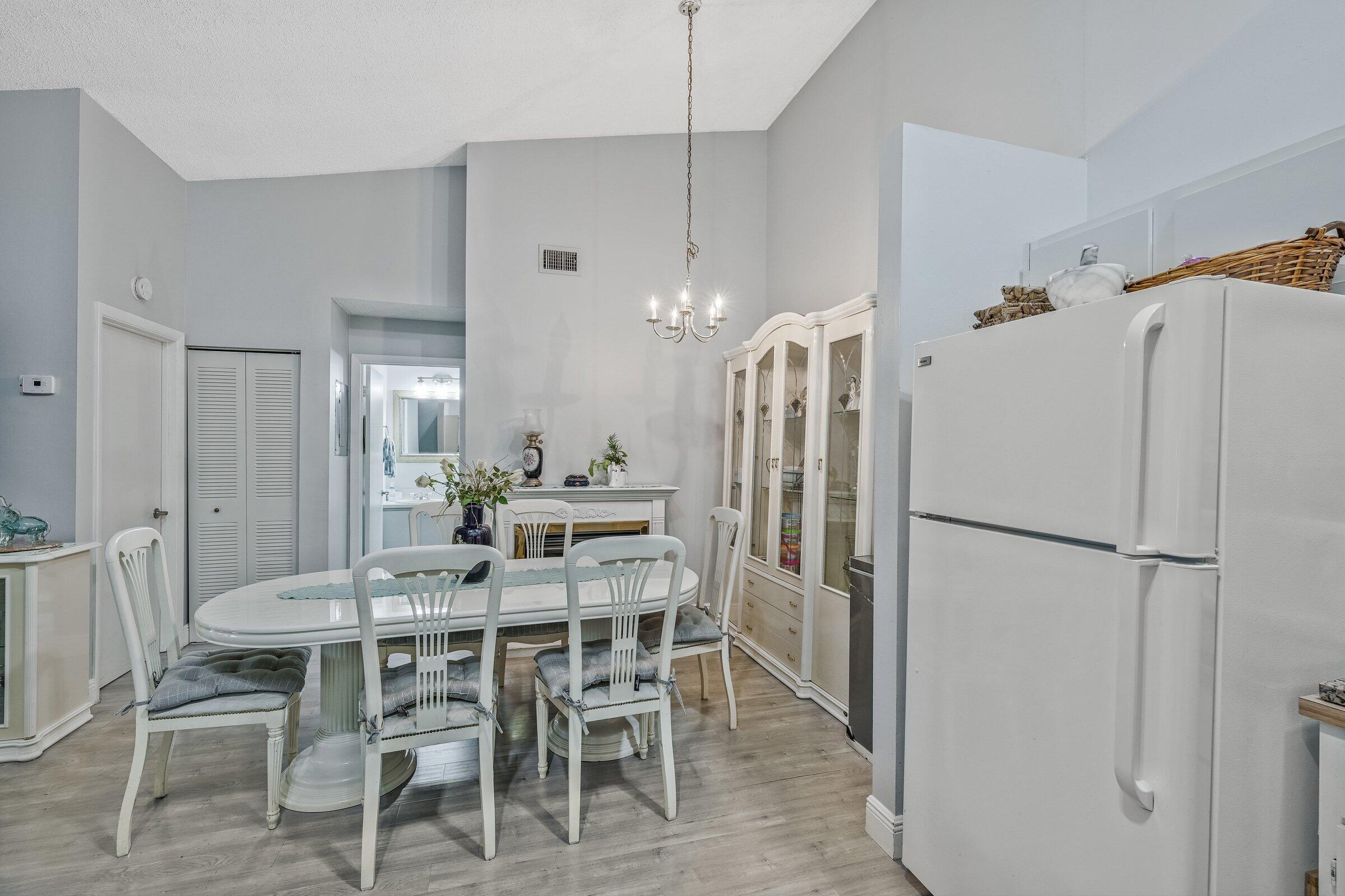 6544 Chasewood Drive, Unit H Jupiter, FL 33458 - Photo 7 of 14 a kitchen with stainless steel appliances a refrigerator and a dining table
