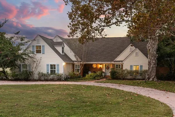 a front view of house with garden and trees