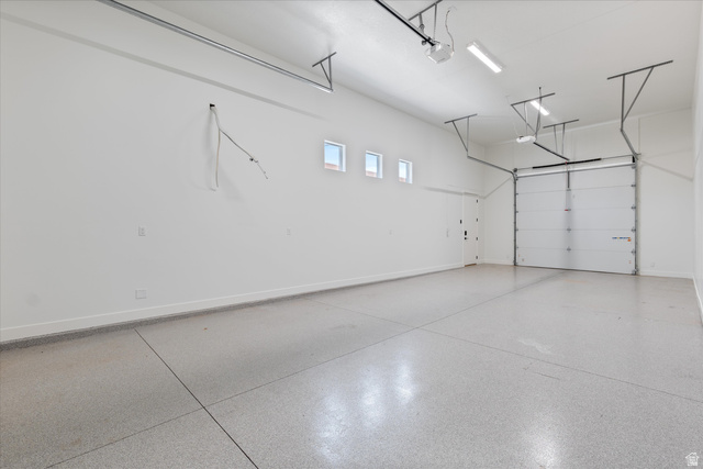 1192 East Corral Way Washington, UT 84780 - Photo 69 of 81 Spacious garage featuring a durable speckled epoxy floor, white walls, and a large overhead door