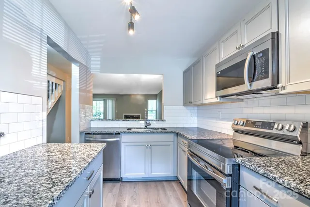 a kitchen with stainless steel appliances granite countertop a sink stove and oven