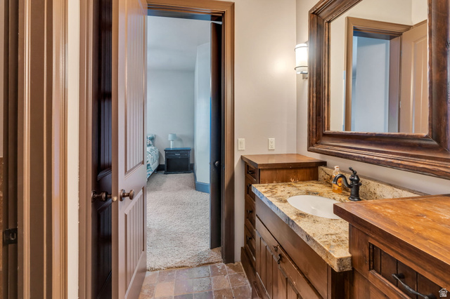 811 South High Ridge Drive Alpine, UT 84004 - Photo 57 of 98 Ensuite bathroom featuring vanity, light stone finish floors, and light carpet