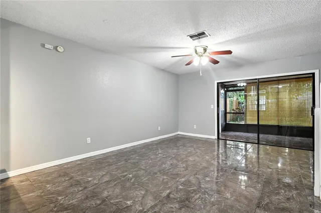 an empty room with fan and windows