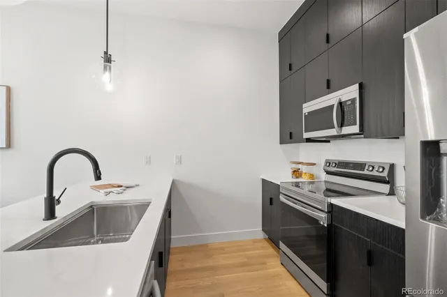 a kitchen with stainless steel appliances a stove a sink and a microwave