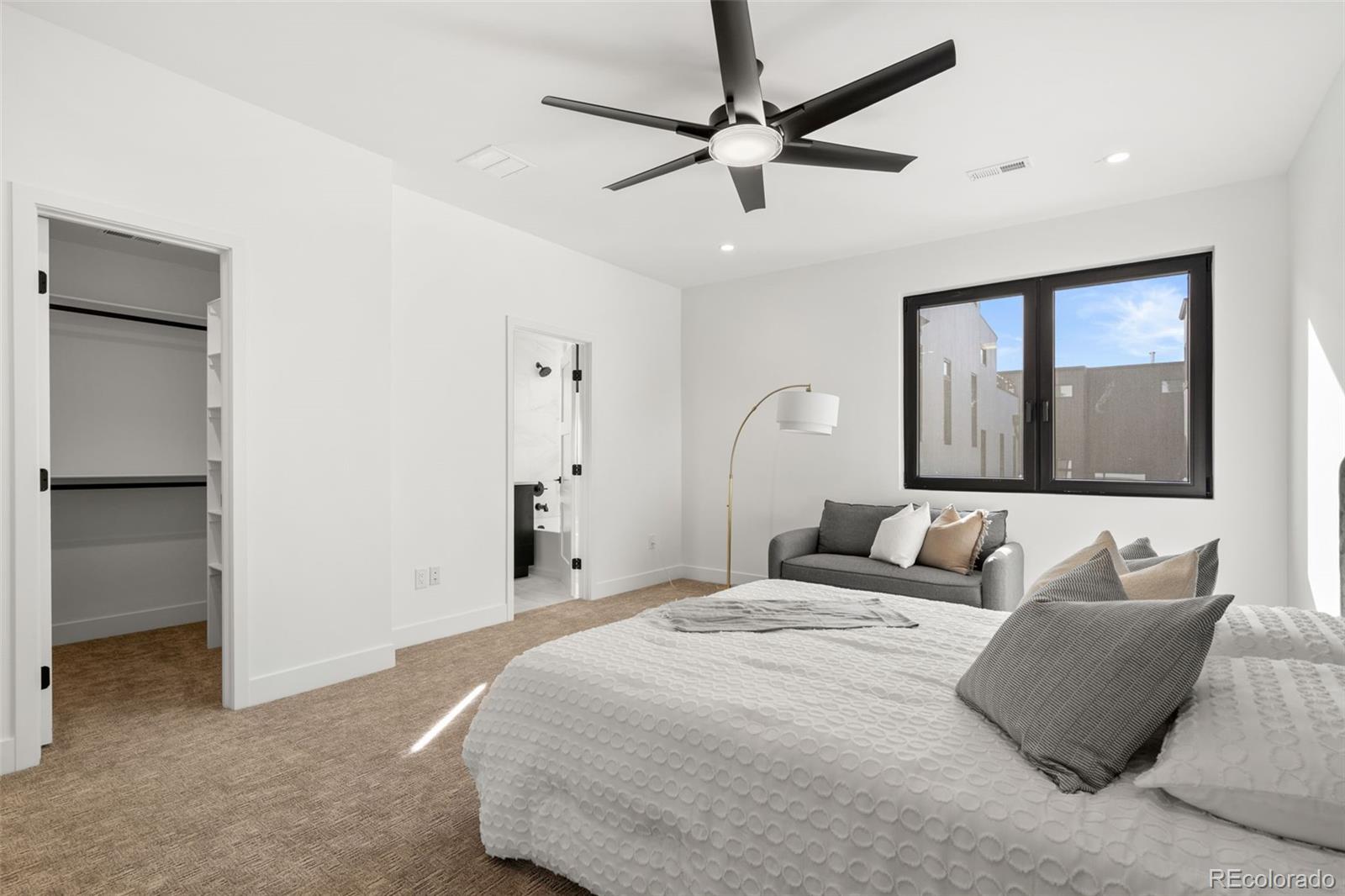 1256 Yates Street Denver, CO 80204 - Photo 16 of 26 a bedroom with a large bed and a chandelier