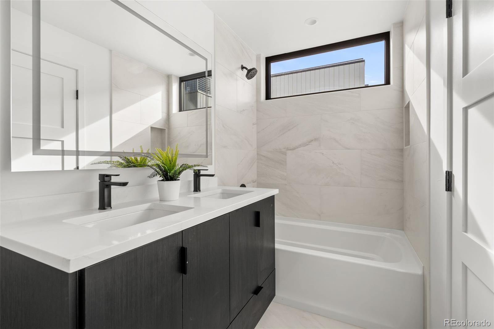 1256 Yates Street Denver, CO 80204 - Photo 17 of 26 a bathroom with a sink vanity tub and a mirror