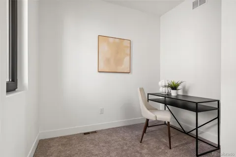 a dining room with furniture and a potted plant